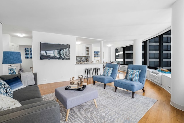 living room with cooling unit and light hardwood / wood-style flooring