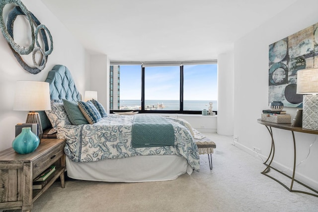 bedroom featuring a water view and light colored carpet