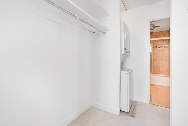 spacious closet featuring ceiling fan and stacked washer / dryer