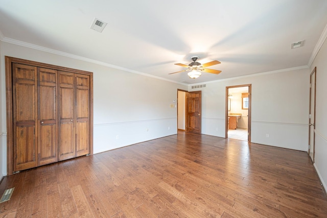 unfurnished bedroom featuring crown molding, hardwood / wood-style floors, and ceiling fan