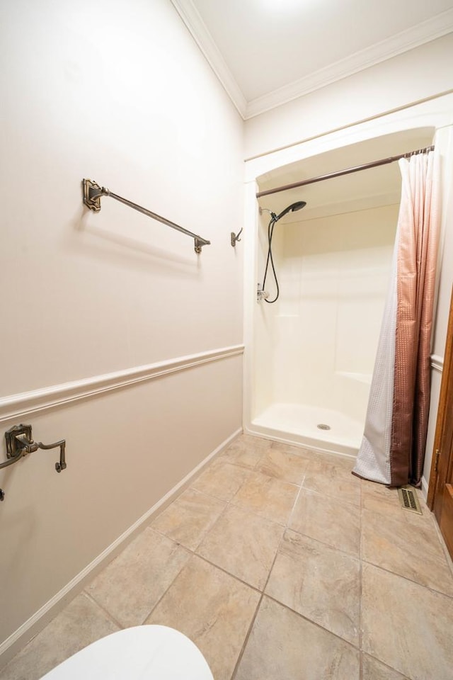 bathroom with ornamental molding, toilet, and a shower with curtain