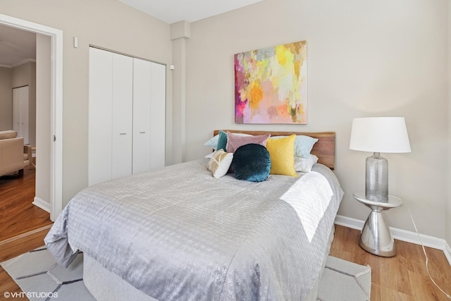 bedroom with a closet, baseboards, and wood finished floors