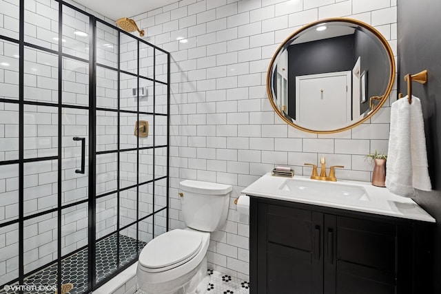 bathroom with vanity, tile walls, toilet, and a stall shower