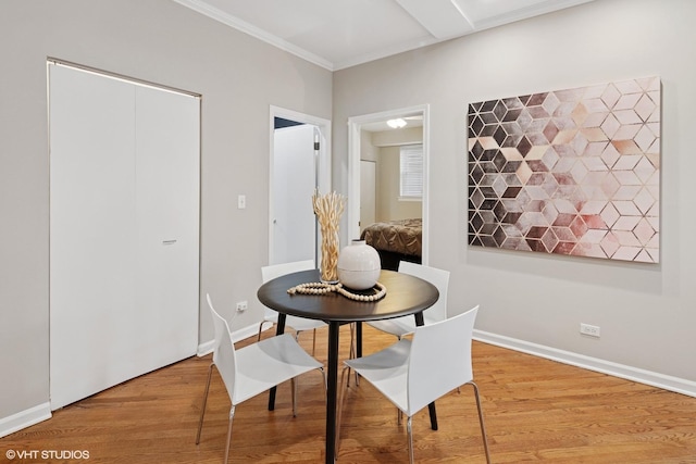 dining space with light wood-type flooring, baseboards, and ornamental molding