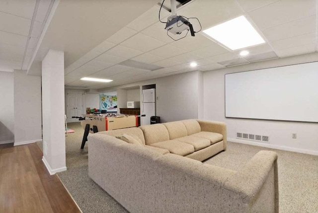 home theater featuring a paneled ceiling and hardwood / wood-style floors