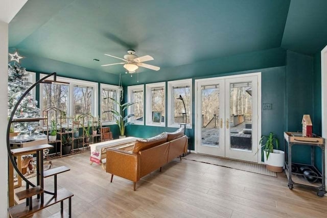 living room featuring ceiling fan, lofted ceiling, light wood-type flooring, and french doors