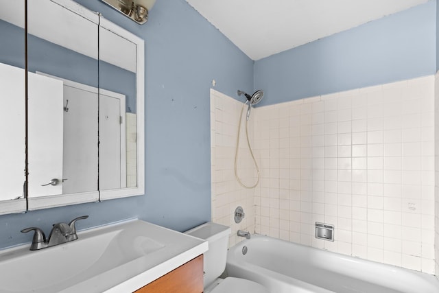 full bathroom with vanity, tiled shower / bath, and toilet