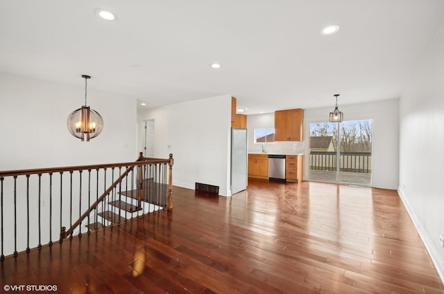 living room with a notable chandelier and dark wood-type flooring