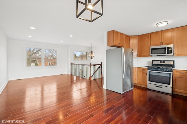 kitchen featuring dark hardwood / wood-style floors, stainless steel appliances, decorative light fixtures, and a chandelier