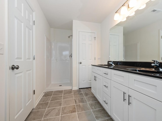 bathroom with vanity, tile patterned flooring, and walk in shower