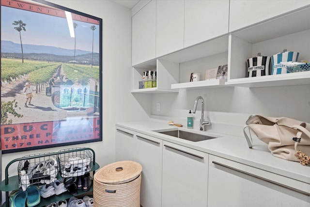 bar with a mountain view, sink, and white cabinets