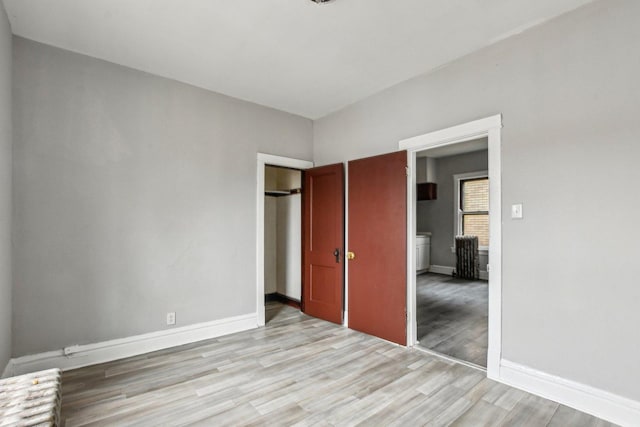 unfurnished bedroom featuring light hardwood / wood-style flooring and a closet