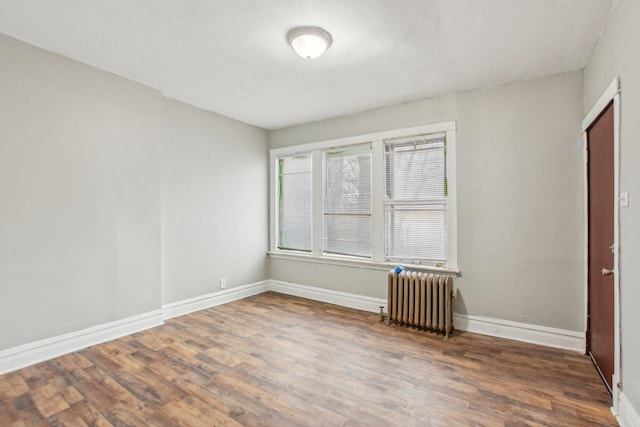 spare room with radiator and dark hardwood / wood-style flooring