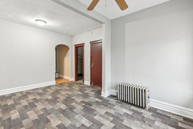 empty room with ceiling fan and radiator