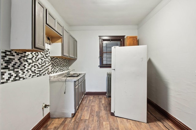 kitchen with gray cabinets, dark hardwood / wood-style floors, tasteful backsplash, sink, and white refrigerator