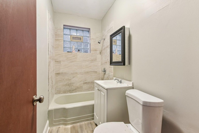 full bathroom with tiled shower / bath, vanity, toilet, and hardwood / wood-style floors