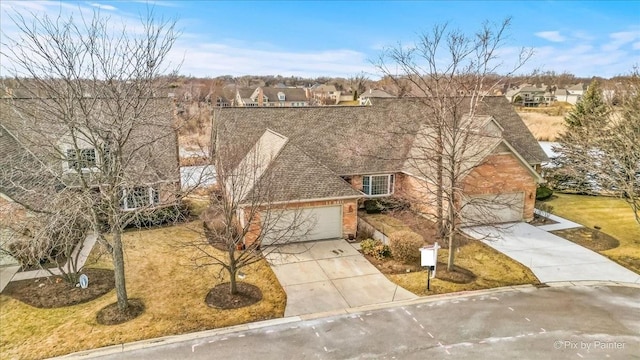 traditional home featuring driveway, a shingled roof, and a garage