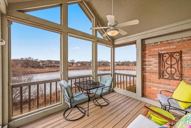 sunroom / solarium featuring a water view, a wealth of natural light, lofted ceiling, and ceiling fan