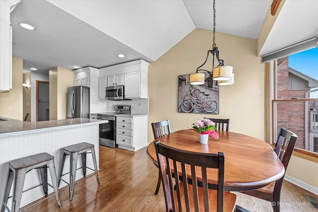 dining space with lofted ceiling and dark hardwood / wood-style flooring