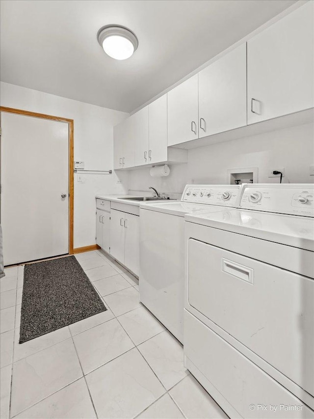 clothes washing area featuring cabinets, sink, light tile patterned floors, and washer and clothes dryer