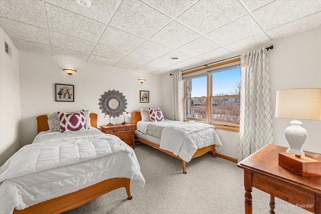 bedroom featuring carpet flooring and a drop ceiling