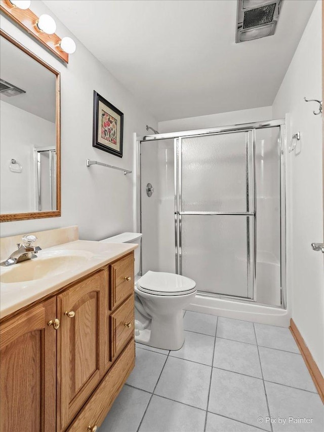 bathroom featuring tile patterned flooring, vanity, an enclosed shower, and toilet