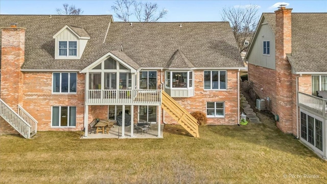 rear view of house with a patio, a sunroom, central AC unit, and a lawn