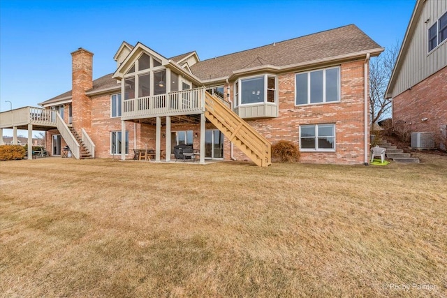 back of property featuring a yard, a deck, a sunroom, and central air condition unit