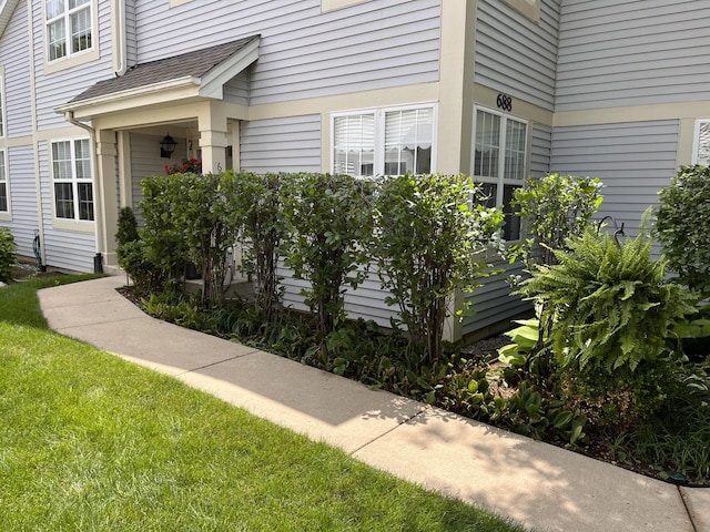 entrance to property featuring a shingled roof