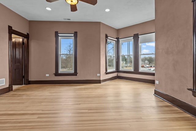 spare room with ceiling fan, light hardwood / wood-style floors, and a wealth of natural light