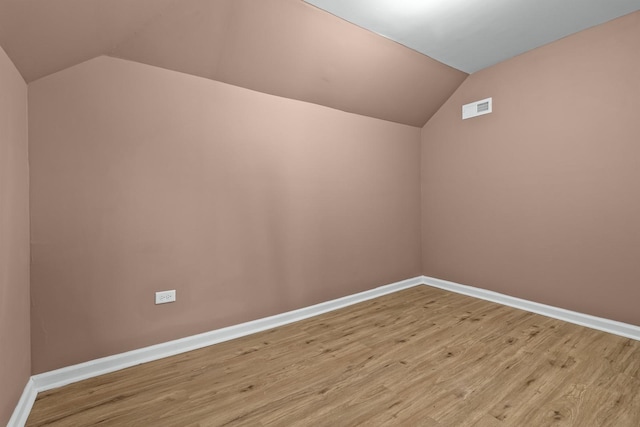 additional living space featuring lofted ceiling and light hardwood / wood-style flooring