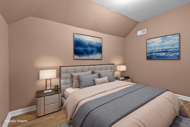 bedroom with vaulted ceiling and light hardwood / wood-style floors