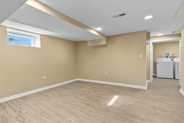 basement with light wood-type flooring and independent washer and dryer