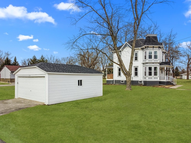 exterior space with a garage, a porch, an outdoor structure, and a yard