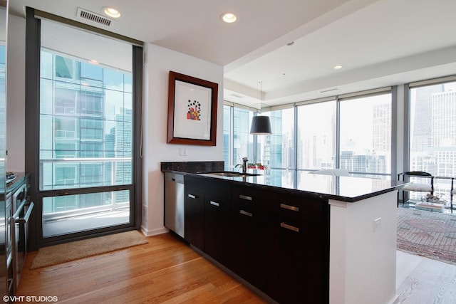 kitchen featuring sink, kitchen peninsula, dishwasher, a wealth of natural light, and pendant lighting