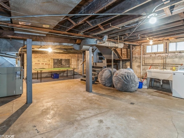 basement with washer / clothes dryer, sink, and heating unit