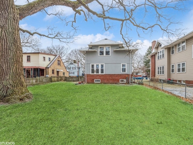 rear view of property featuring a lawn