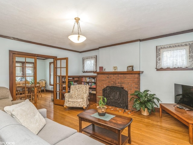 living room featuring ornamental molding, hardwood / wood-style floors, and a brick fireplace