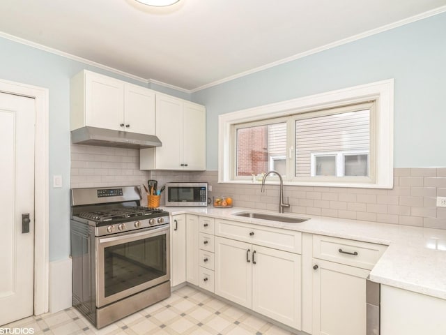 kitchen featuring appliances with stainless steel finishes, sink, white cabinets, light stone counters, and crown molding