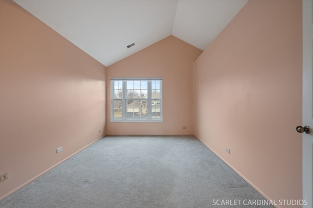 carpeted spare room featuring lofted ceiling