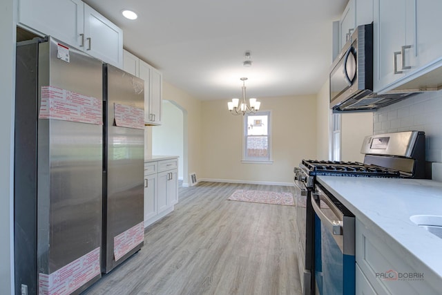 7345 S Washtenaw Ave, Chicago, IL 60629 - kitchen featuring tasteful backsplash, stainless steel appliances, hanging light fixtures, and white cabinets