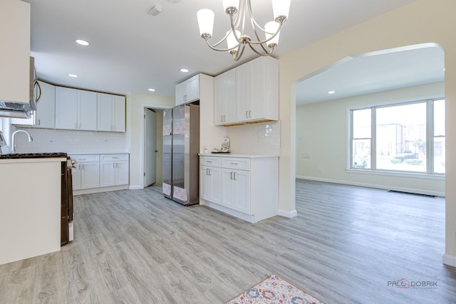 7345 S Washtenaw Ave, Chicago, IL 60629 - kitchen with light wood-type flooring, white cabinetry, stainless steel appliances, and backsplash