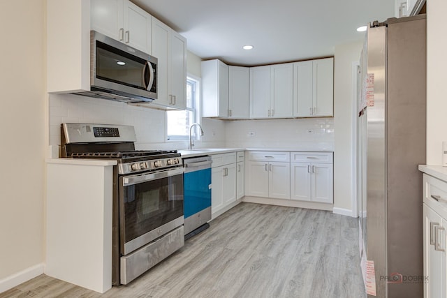 7345 S Washtenaw Ave, Chicago, IL 60629 - kitchen with white cabinets, light wood-type flooring, stainless steel appliances, and tasteful backsplash