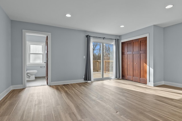 unfurnished bedroom with access to outside, light hardwood / wood-style floors, a closet, and ensuite bathroom