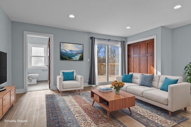 living room with a wealth of natural light and light hardwood / wood-style floors