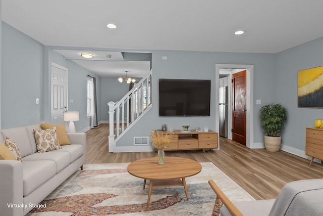 living room with hardwood / wood-style floors and a notable chandelier