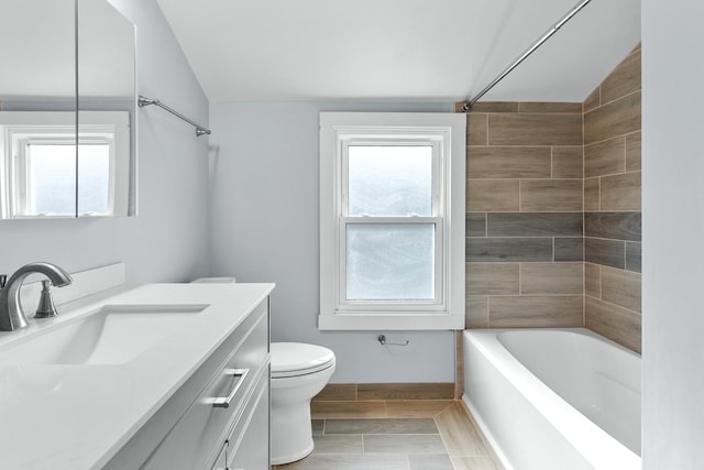 full bathroom with tiled shower / bath combo, vaulted ceiling, a wealth of natural light, and vanity