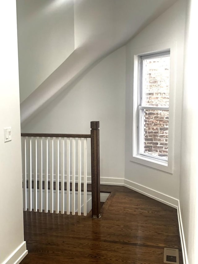 additional living space with vaulted ceiling, dark hardwood / wood-style floors, and a wealth of natural light