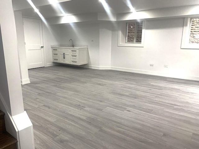 basement featuring sink and hardwood / wood-style floors