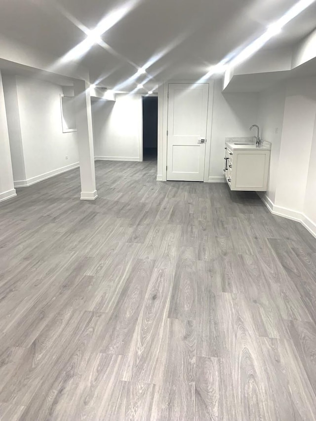 basement with sink and hardwood / wood-style floors